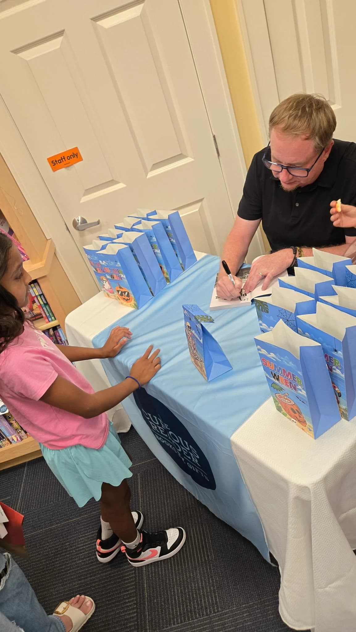 M. D. Payne signing a copy of Pumpkin Apocalypse for a reader