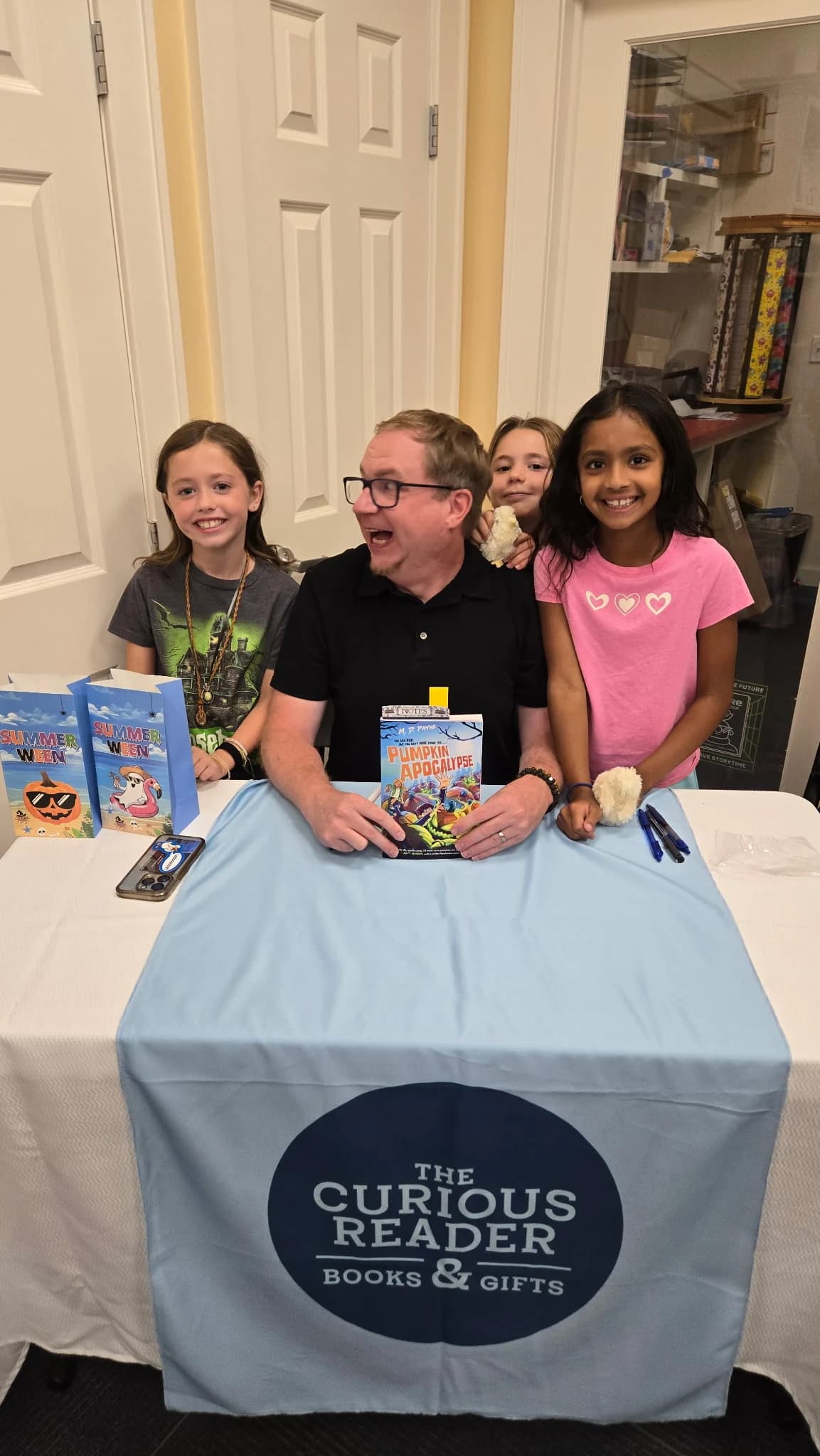 M. D. Payne laughing with young readers while holding Pumpkin Apocalypse